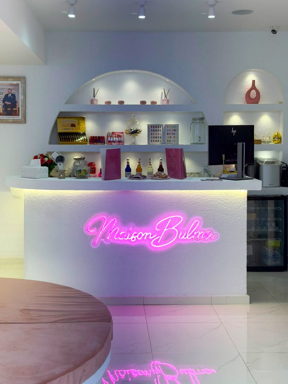 Le comptoir d'accueil de Maison Bulma et son enseigne néon rose